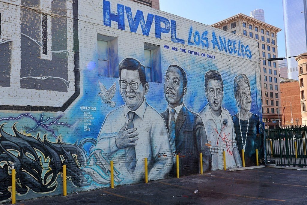 Wall mural on a brick building headed HWPL LOS ANGELES and WE ARE THE FUTURE OF PEACE, with painted portraits of Lee Man-hee with his hand on his heart and a dove beside him, Martin Luther King Jr. beside him, and two further portraits.